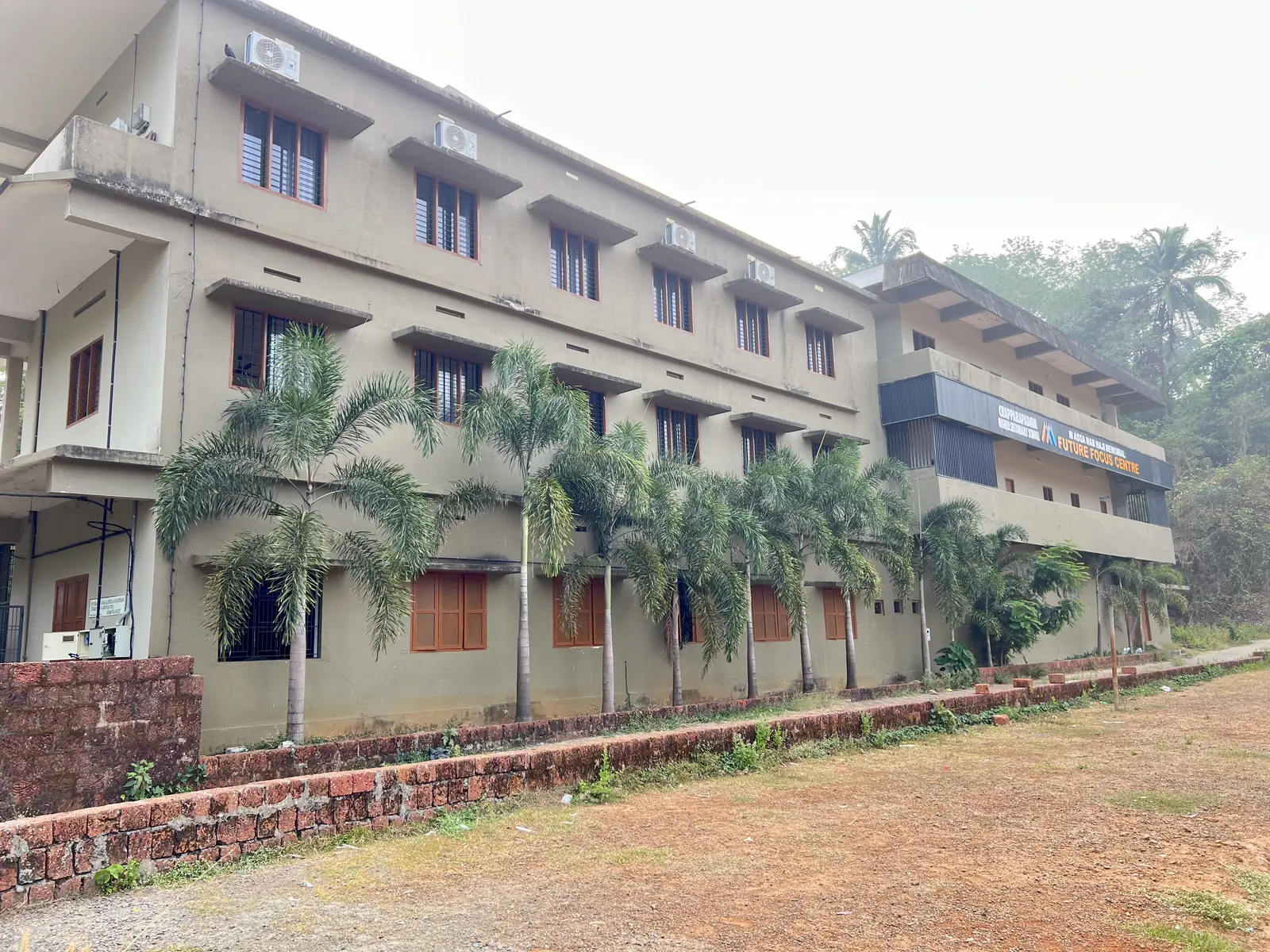 Main academic block of Chapparapadavu Higher Secondary School with palm trees and lawn